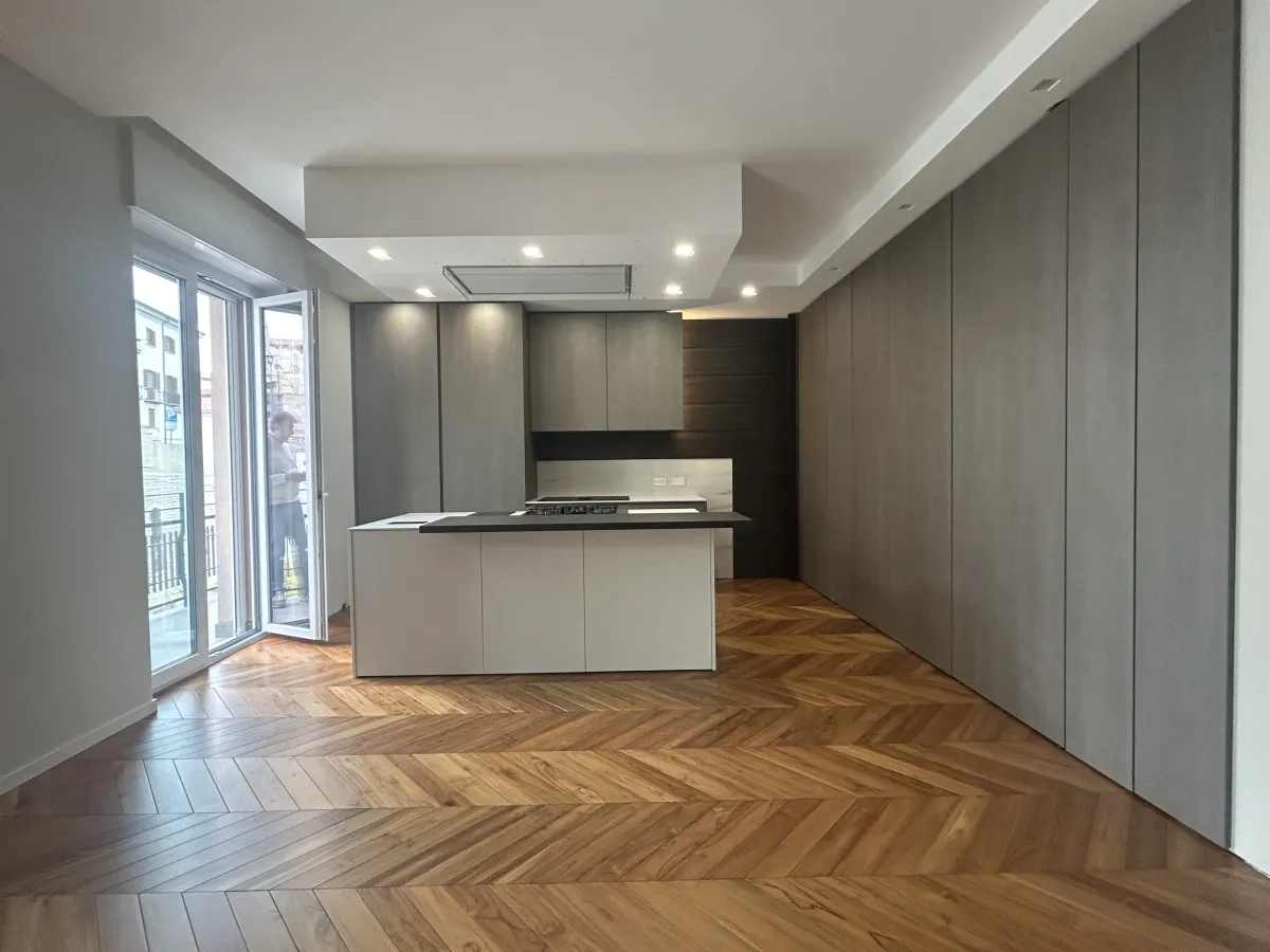 Cucina a isola con colonne grigie e parquet a spina