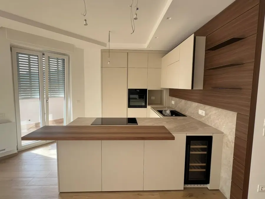 Cucina con parete in noce: penisola e parete in noce
